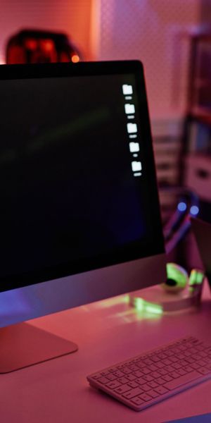 Computer monitor with decoded data on screen standing next to laptop on desk in large contemporary openspace office at night